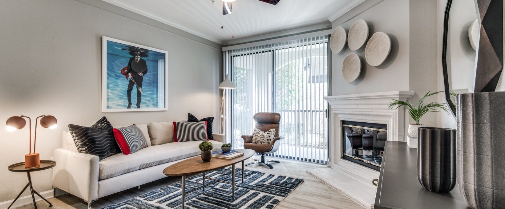 a living room with a fireplace and a ceiling fan at The  Vincent