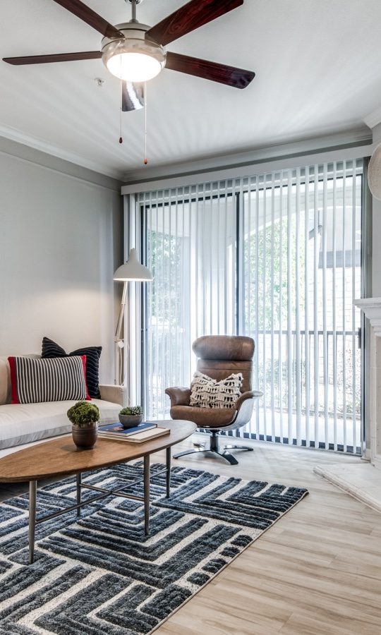 a living room with a fireplace and a ceiling fan at The  Vincent