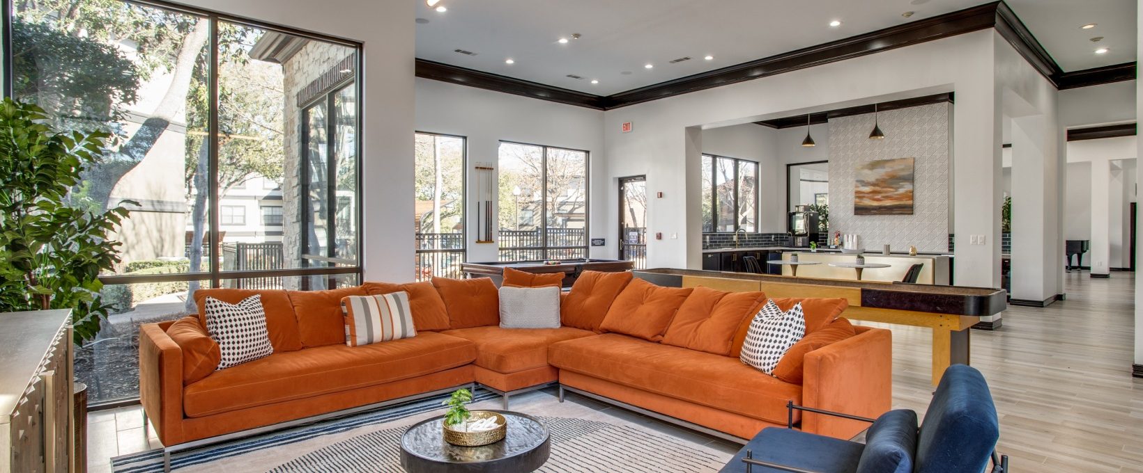 a living room with orange couches and a large window at The  Vincent
